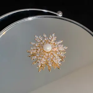 Nahaufnahme einer edlen vergoldeten Schneeflocken-Brosche mit Zirkonia-Steinen und Perle