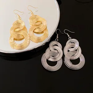 Detaillierte Makroansicht schicker gold- und silberfarbener runder Spiral-Ohrhänger