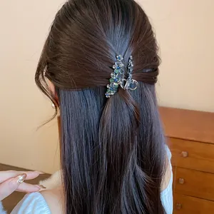 Detail shot of elegant resin flower and rhinestone hair clip on dark brown hair