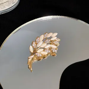 Detaillierte Makroaufnahme einer eleganten vergoldeten Weizenblatt-Brosche mit Zirkonia