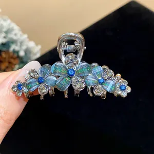 Detailed macro view of an iridescent resin flower hair clip with blue rhinestones