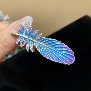 Close-up macro view of a stunning blue iridescent feather hair clip with sparkling rhinestones