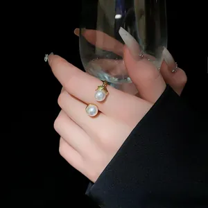 Close-up view of a vintage pearl open ring with pleated texture on a model's finger.