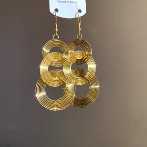 Detailansicht der goldfarbenen, kreisförmig geschichteten Metall-Ohrhänger