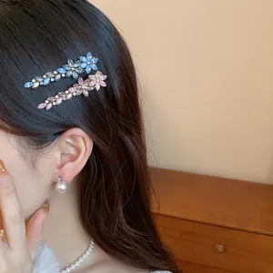 Elegant rhinestone flower and feather hair clips elegantly styled on brown wavy hair