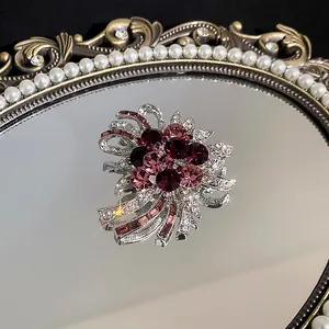 Detailaufnahme einer eleganten Brosche mit lila Kristallen auf einem Perlspiegel