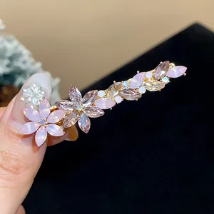 Close-up of exquisite rhinestone flower hair clip with sparkling pink resin crystals.