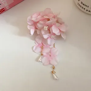 Détail d'une pince à cheveux fleur en tissu avec d'élégants glands en perles d'eau