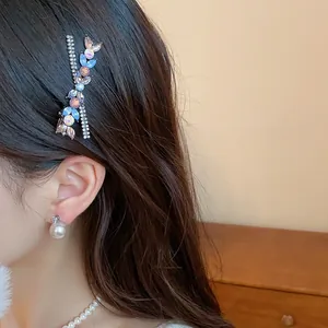 Close-up detail of a floral rhinestone resin hair clip elegantly worn on model's dark hair