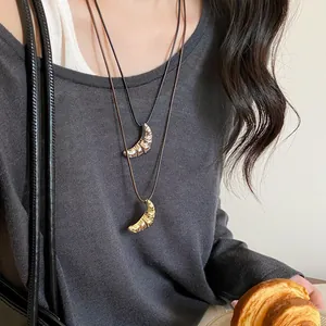 Collana minimalista con ciondolo a croissant e cordino in pelle per donna, oro e argento