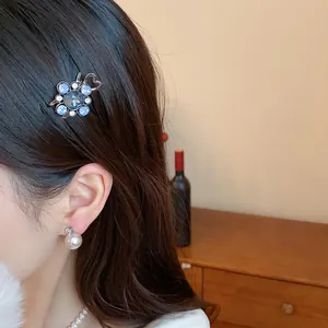 Detailed view of an elegant blue resin flower hair clip with rhinestones on hair
