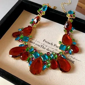 Détail d'un collier vintage avec des gouttes de cristal colorées sur monture dorée
