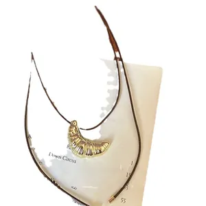 Elegante collana minimalista con ciondolo a croissant dorato su cordino in pelle nera