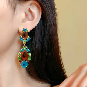 Détail en gros plan de boucles d'oreilles vintage avec strass multicolores sur mannequin
