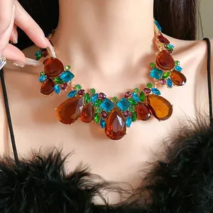 Gros plan d'un collier plastron vintage avec strass colorés en forme de gouttelette.