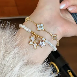 Close-up of 18k gold plated pearl bracelet with zircon pony and star charms