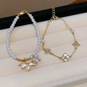 Close-up detail of 18k gold plated pearl bracelet with pony charm and clover motifs