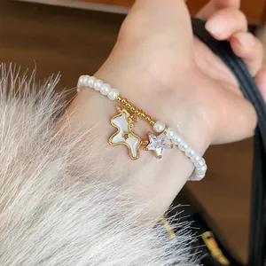 Close-up detail of a pearl bracelet featuring a gold-plated unicorn and sparkling zircon star charm