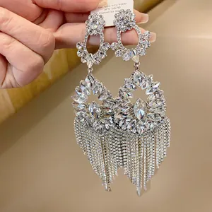 Macro detail of luxurious silver earrings featuring flower patterns and rhinestone fringe