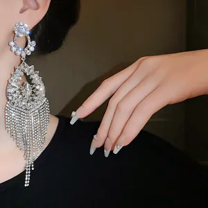 A detailed view of luxury silver teardrop earrings with long sparkling crystal tassels