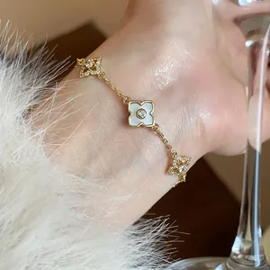Detailed view of an 18k gold plated bracelet with zircon-encrusted flower motifs.
