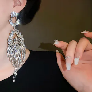 Detailed macro view of sparkly silver flower teardrop earrings with long crystal tassels.