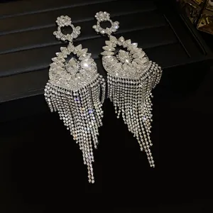Close-up of sparkling rhinestone flower earrings with long shimmering fringe tassels.
