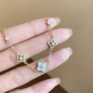 Close-up of 18k gold plated bracelet with zircon-encrusted flower charms