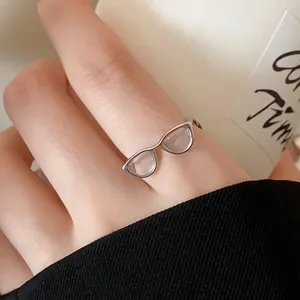 Detailed view of a unique silver open ring featuring a minimalist eyeglasses design