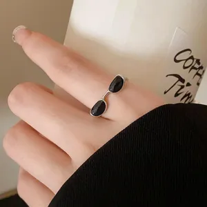 Detailed shot of a creative silver sunglass-shaped ring with black enamel drip