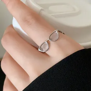 Detail view of a creative glasses shaped open ring with clear dripping oil inlay