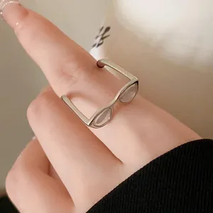 Close-up of a silver spectacles-shaped open ring with Korean-style drip oil detail.