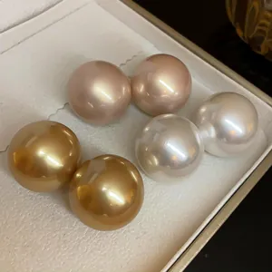 Dettaglio di grandi orecchini a perla vintage nei colori bianco, oro e rosa champagne