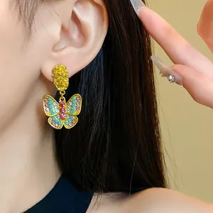 Detailed close-up showing a vintage butterfly drop earring with colorful rhinestones