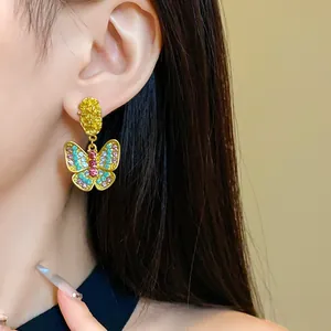 Close-up of vintage butterfly drop earrings with colorful rhinestones on a model