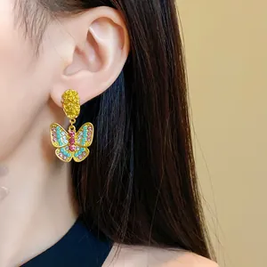 Vintage gold plated butterfly drop earrings with colorful crystals worn by model