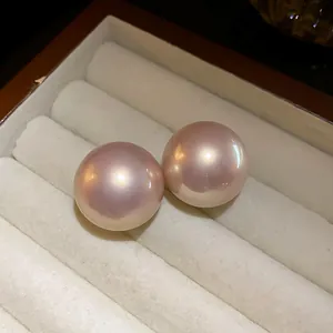 Primo piano di orecchini a perno con perle rosa rotonde in una scatola regalo lussuosa