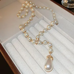 Dettaglio del ciondolo a goccia di perla elegante con accenti dorati lucenti
