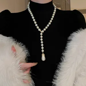 Elegante collana di perle a goccia con dettagli in cristallo su un dolcevita nero