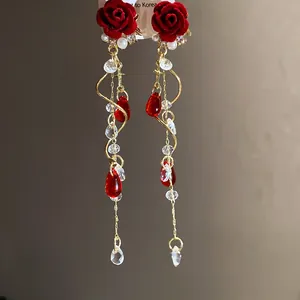 Detailed view of vintage velvet rose earrings with pearls and long tassel accents.