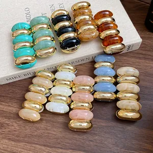 Detailed view of multiple retro marbled acrylic and gold-tone segment bracelets in various colors