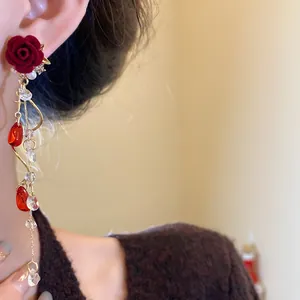 Detail of retro red flocked rose earrings with dangling pearls and crystal tassels