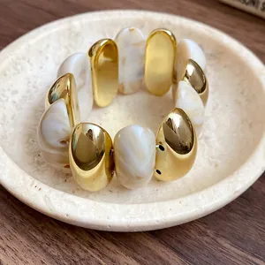 Close-up view of vintage marbled acrylic and gold-toned chunky oval link bracelet
