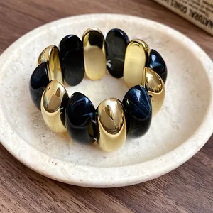 Detailed view of a vintage acrylic stretch bracelet with marbled black and gold oval beads