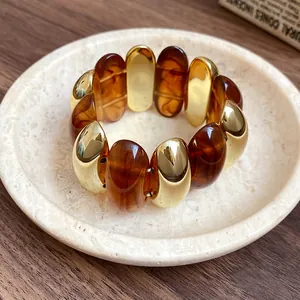 Close-up of a vintage style acrylic tortoise shell bracelet with polished gold oval beads