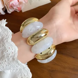 Detailed view of chunky gold and marbled white acrylic spliced vintage bracelet for women