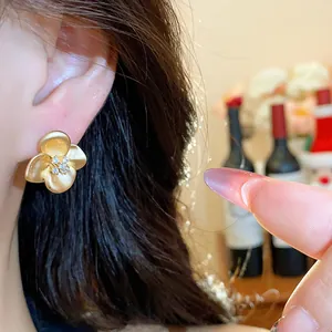 Detailed macro shot of vintage matte gold flower stud earrings with zircon crystals