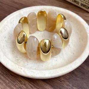 Detailed macro view of marbled acrylic and gold-toned oval links on a chunky retro bracelet