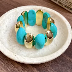 Detailed view of turquoise marbled acrylic and gold oval spliced retro bangle bracelet