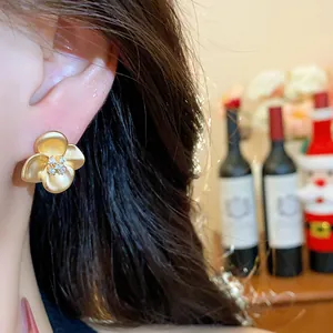 Detailed close-up of vintage golden flower stud earrings with sparkling zirconia center